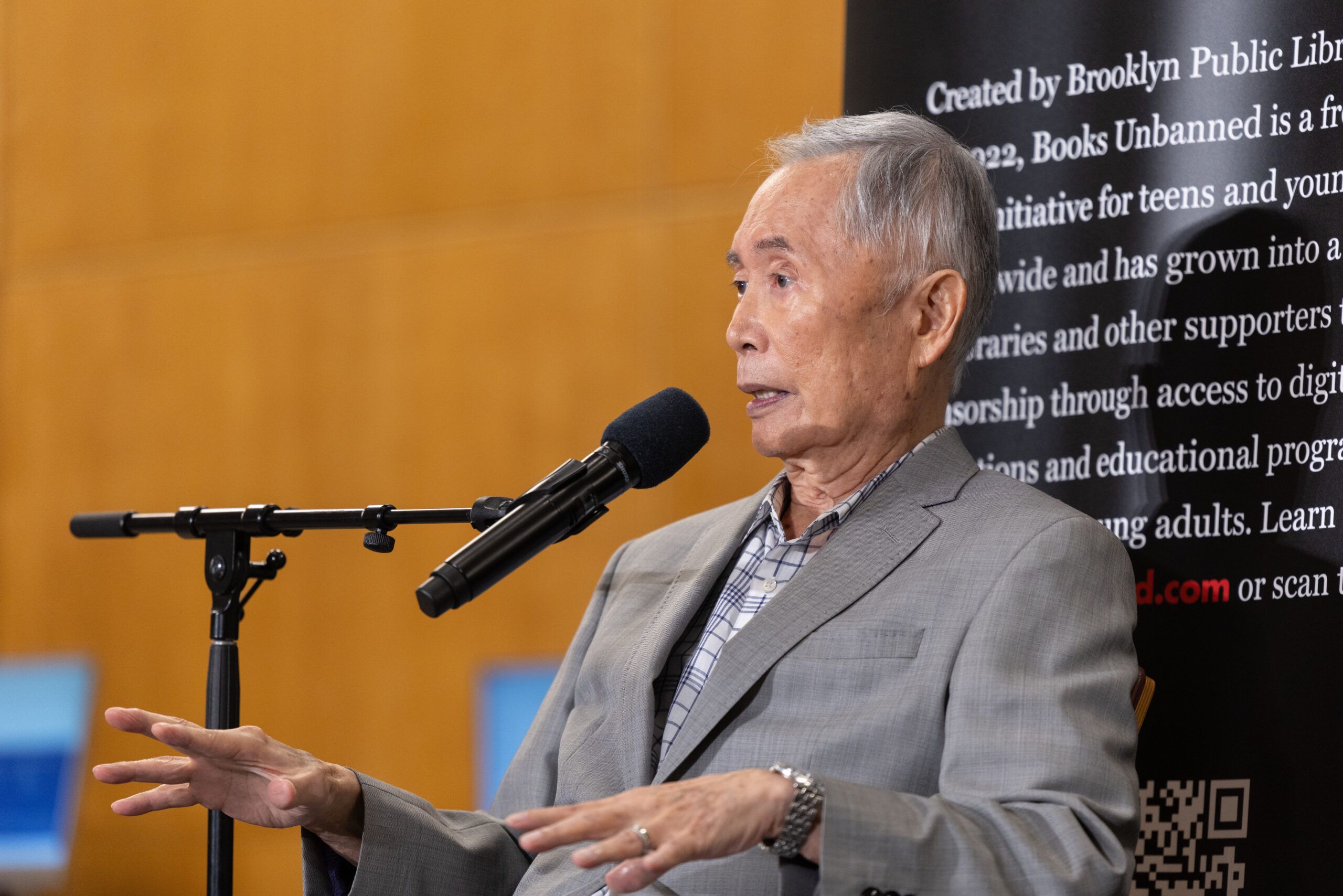 Image of George Takei speaking at a microphone.