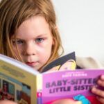 a photo of a kid reading a Babysitters Little Sister graphic novels